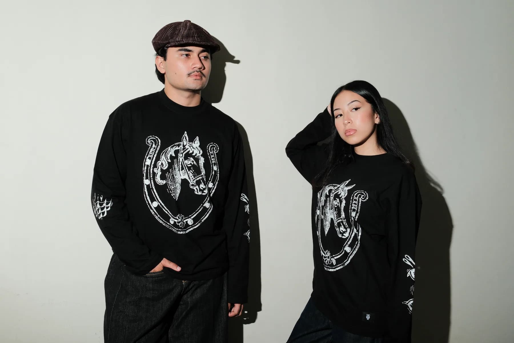 Two models show the front and back of their TOHO outfits against a light studio wall.